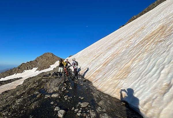 Group of cyclists on a snowfield in Sierra Nevada